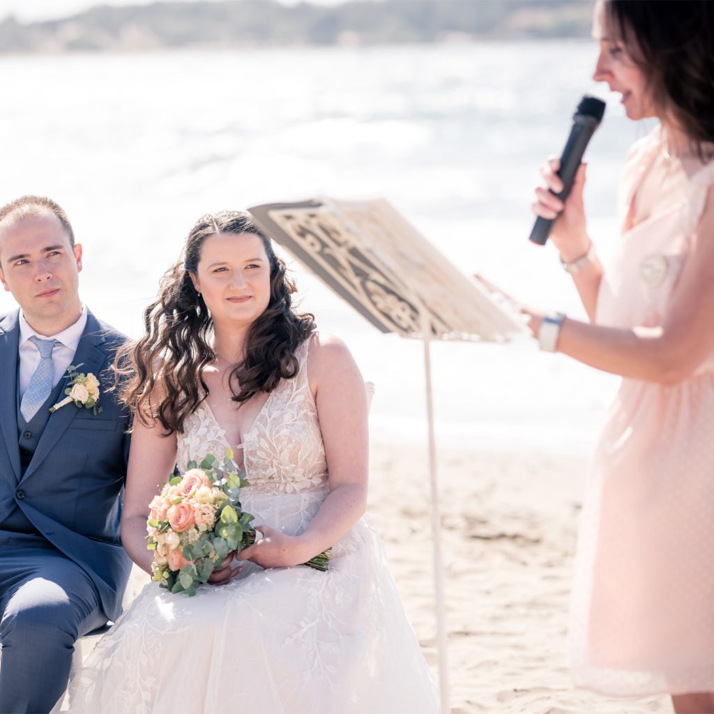 Lecture d'un discours pendant une cérémonie laïque de mariage en bord de mer.