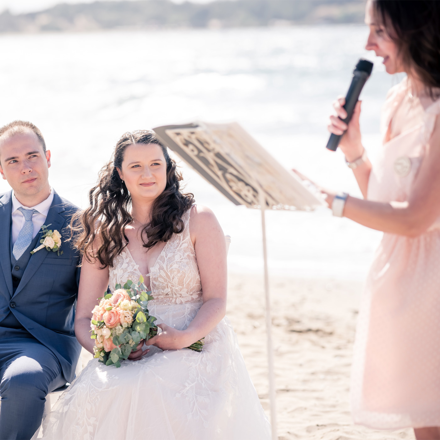 Lecture d'un discours pendant une cérémonie laïque de mariage en bord de mer.