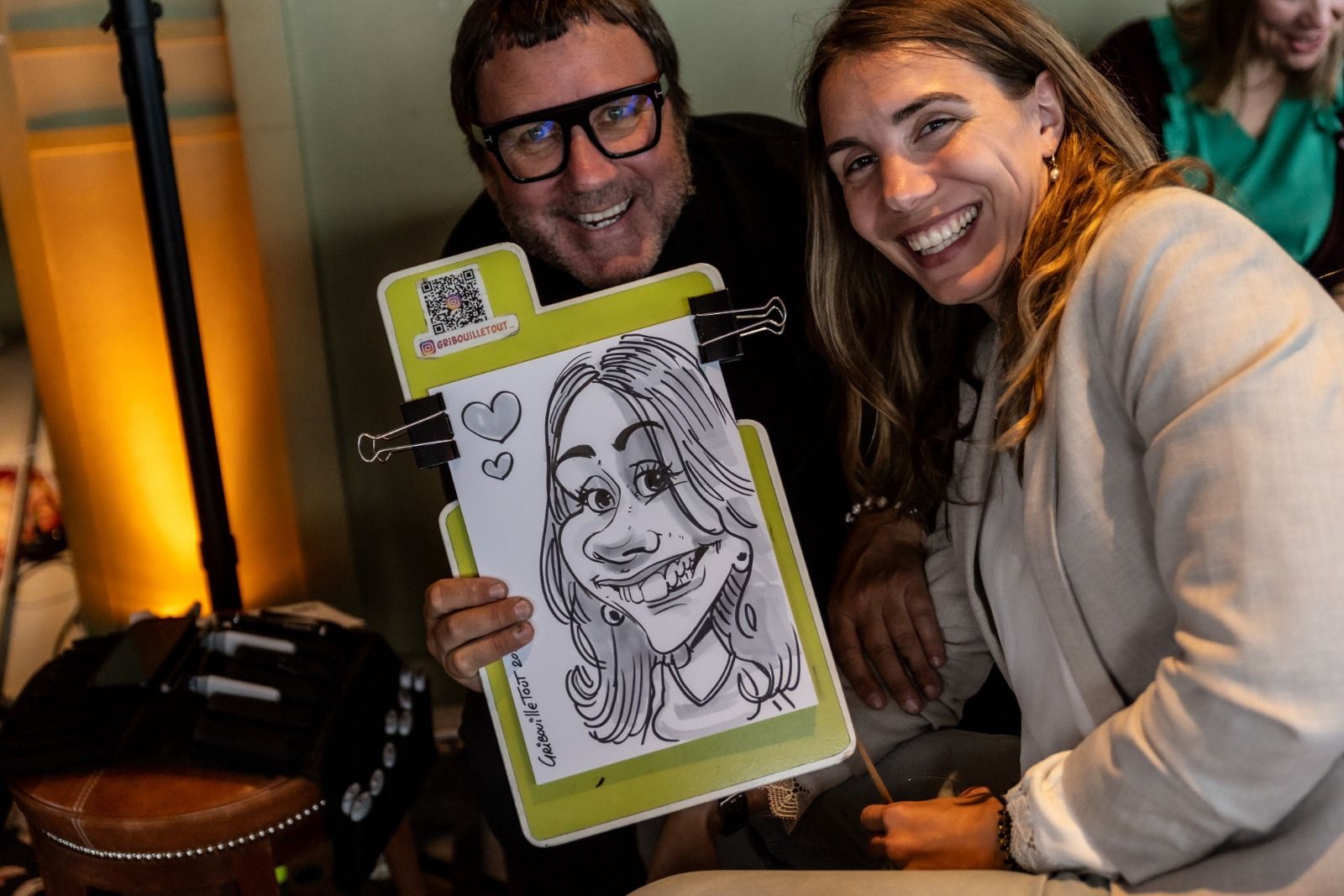 Invités présentant une caricature réalisée pendant la soirée d’entreprise