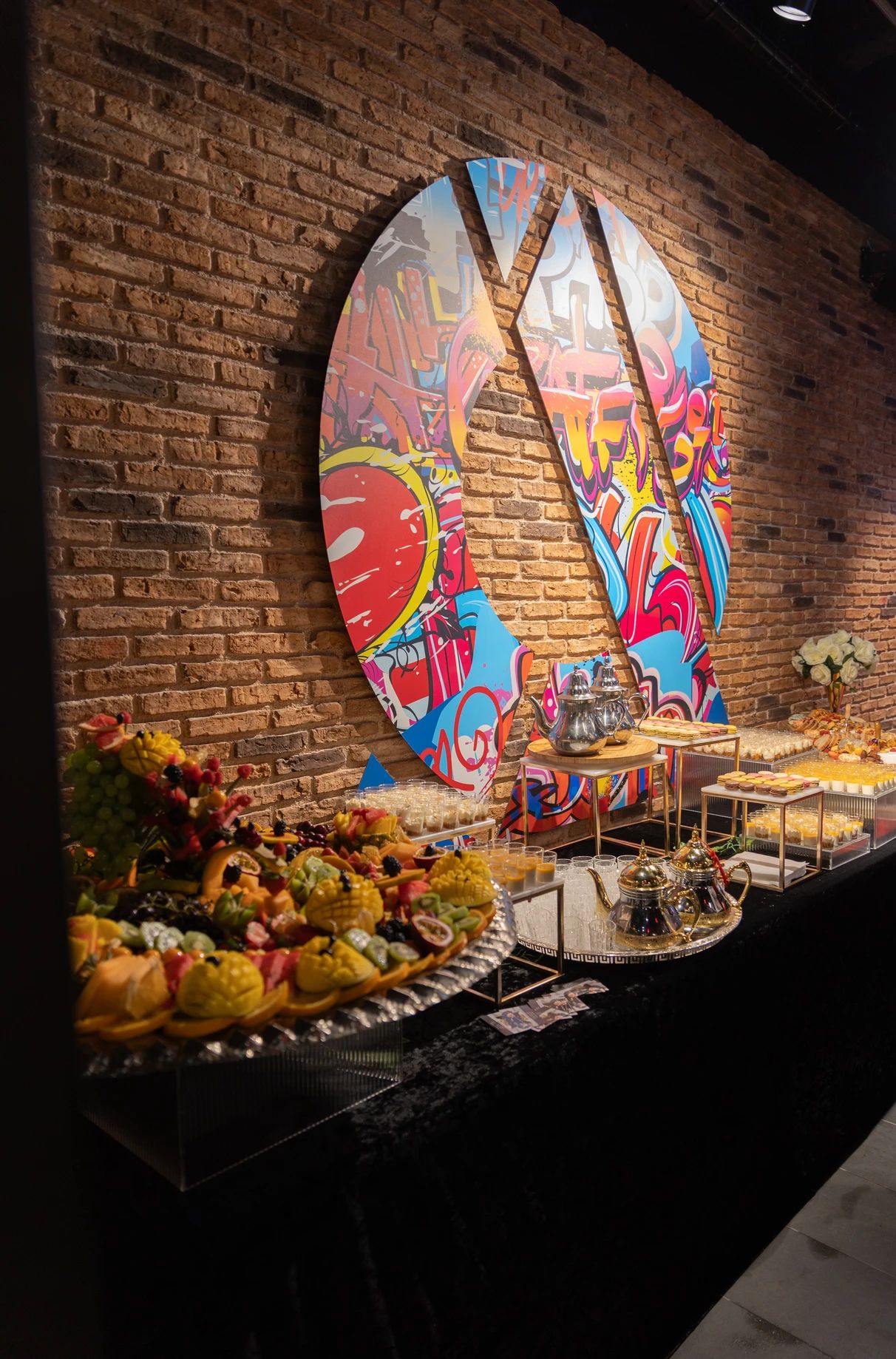 Buffet présenté devant une décoration murale colorée pendant l’événement