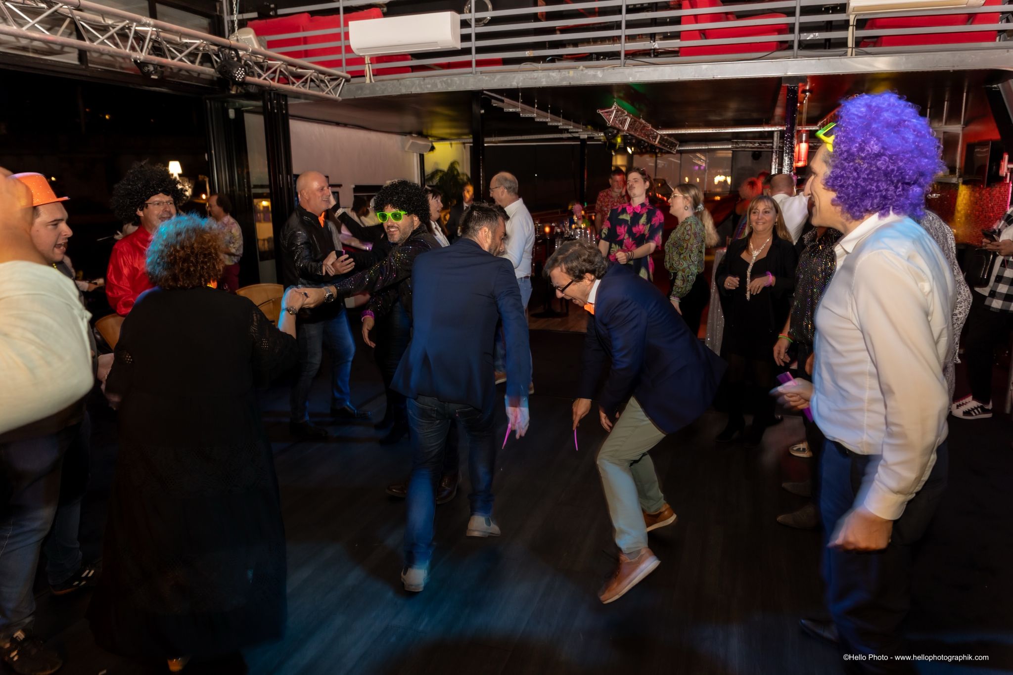 Collaborateurs dansant avec des perruques colorées pendant la soirée d’Air Climat