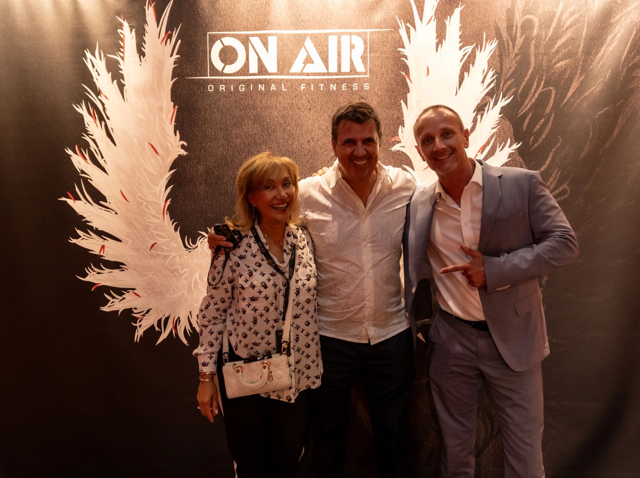 Trois invités devant le photobooth de la convention On Air Fitness à Paris