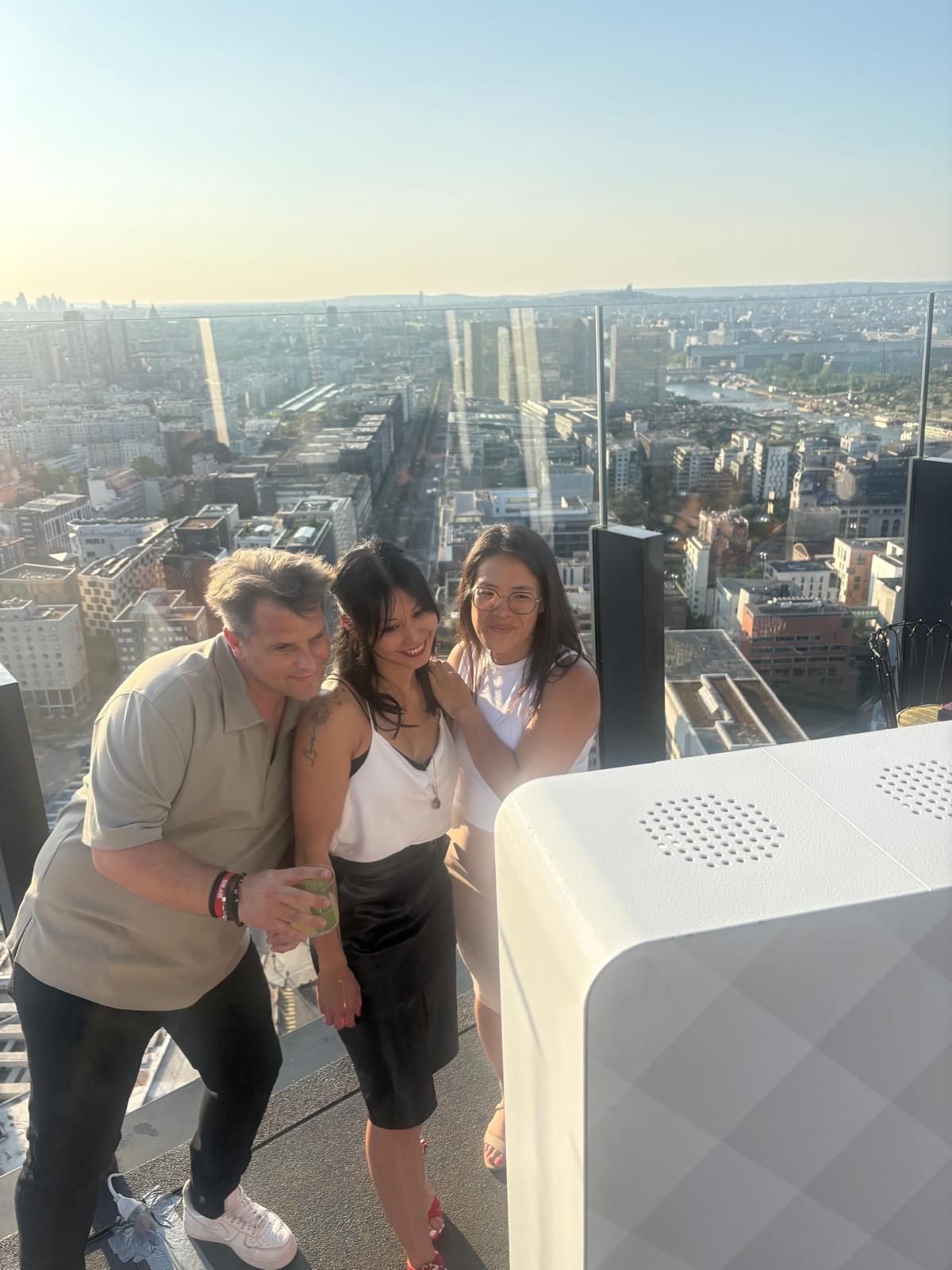 Trois participantes devant le photobooth avec une vue panoramique sur Paris